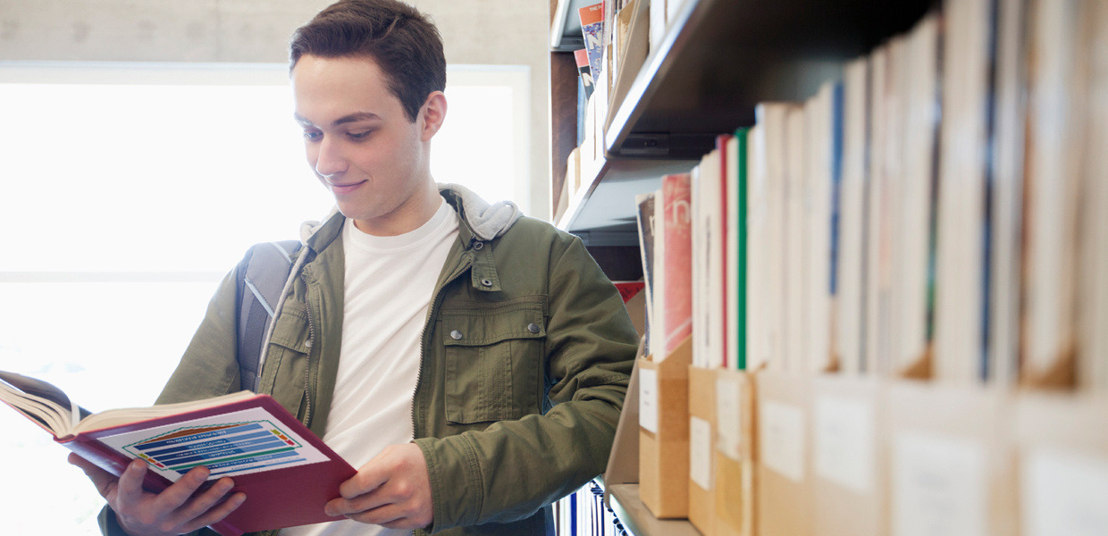 Buch lesender Mensch mit Bücherregal im Hintergrund